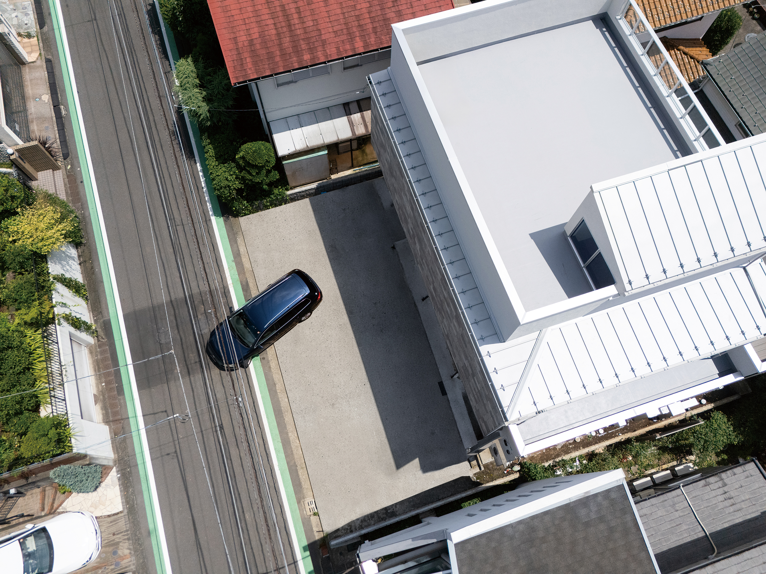駐車スペースと屋上を真上から見下ろした住まいの外観